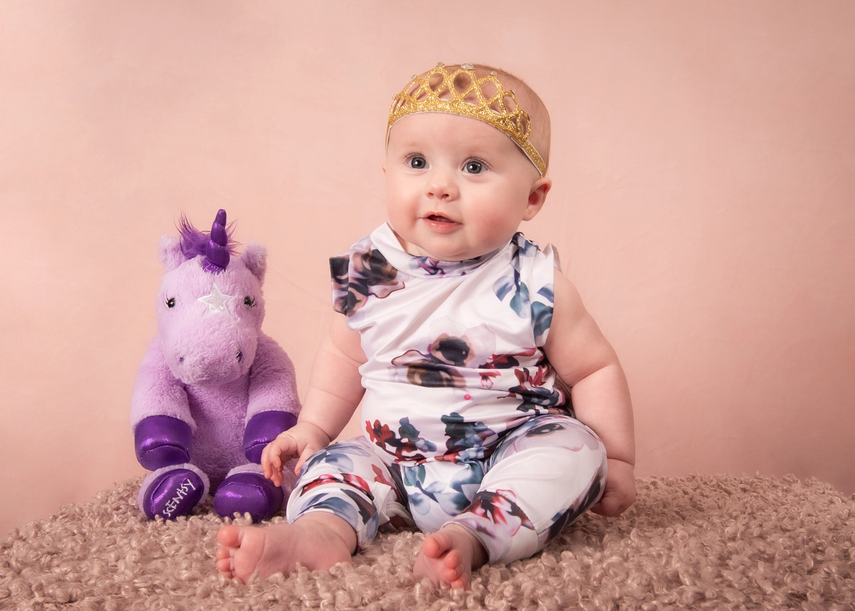 Baby in floral outfit with gold crown headband beside purple unicorn — Edmonton baby milestone session
