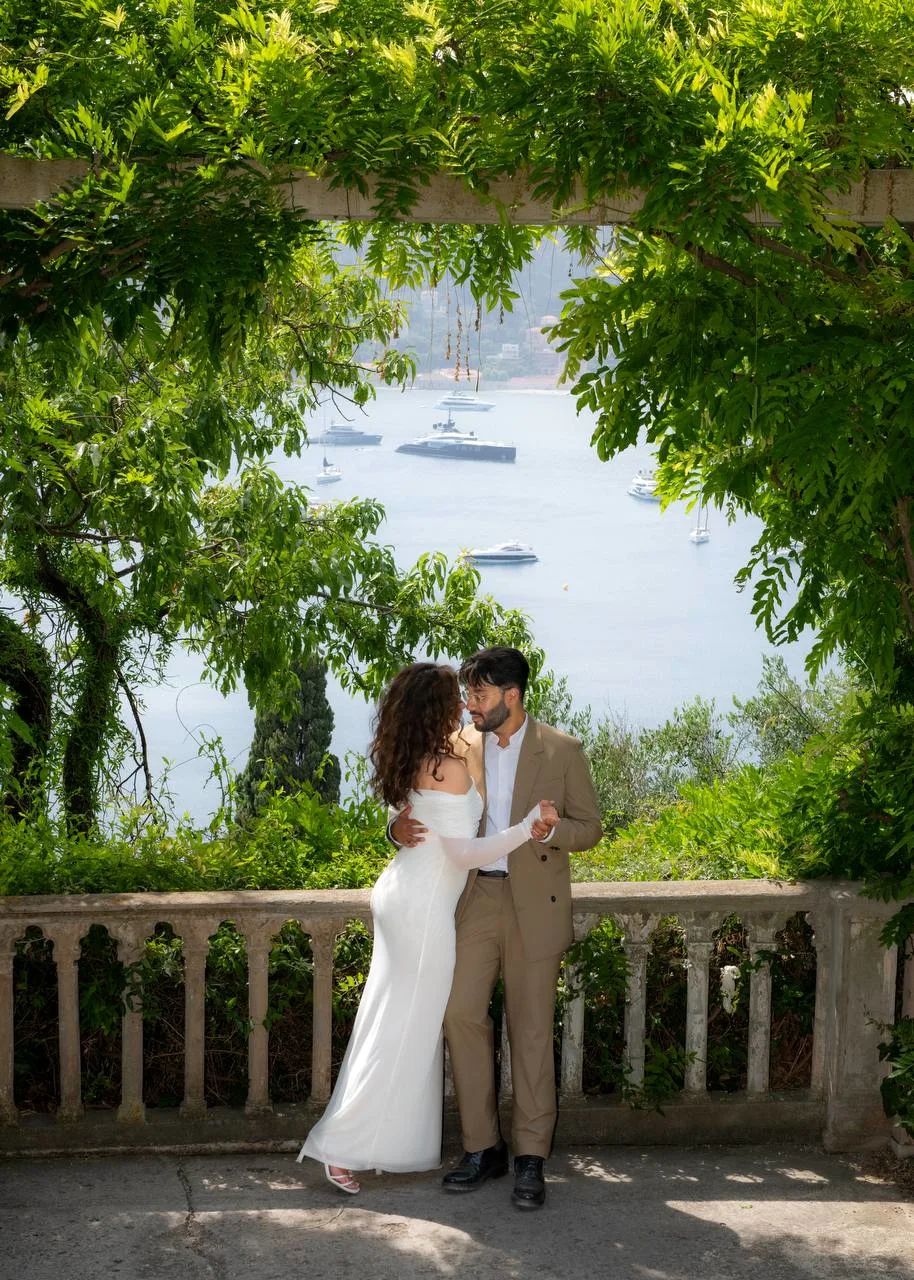 Engagement couple under greenery archway with a scenic waterfront view